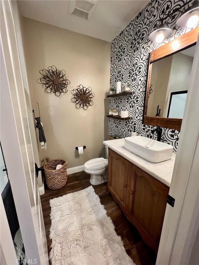 32526 Presidio Hills Ln, Winchester, CA 92596 - bathroom with vanity, wood finished floors, toilet, wallpapered walls, and baseboards