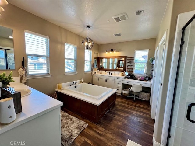 full bath with visible vents, plenty of natural light, a shower stall, and wood finished floors