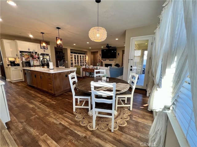 dining space featuring dark wood-style floors, recessed lighting, and a fireplace