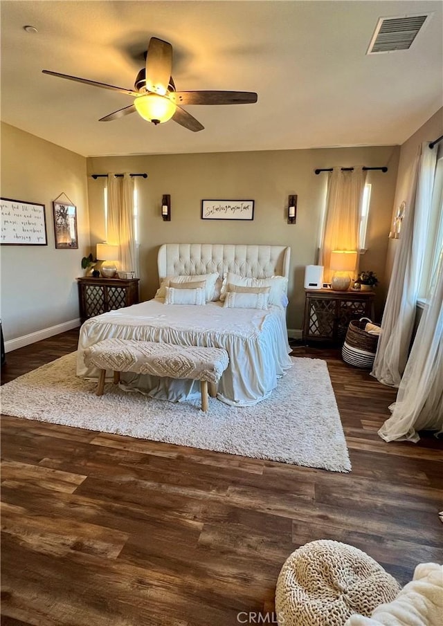 bedroom featuring a ceiling fan, baseboards, visible vents, and wood finished floors