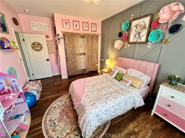 bedroom with wood finished floors and baseboards