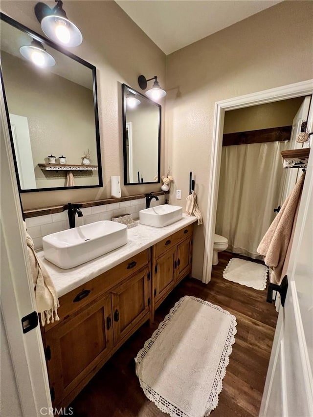 32526 Presidio Hills Ln, Winchester, CA 92596 - bathroom featuring double vanity, wood finished floors, toilet, a shower with shower curtain, and tasteful backsplash