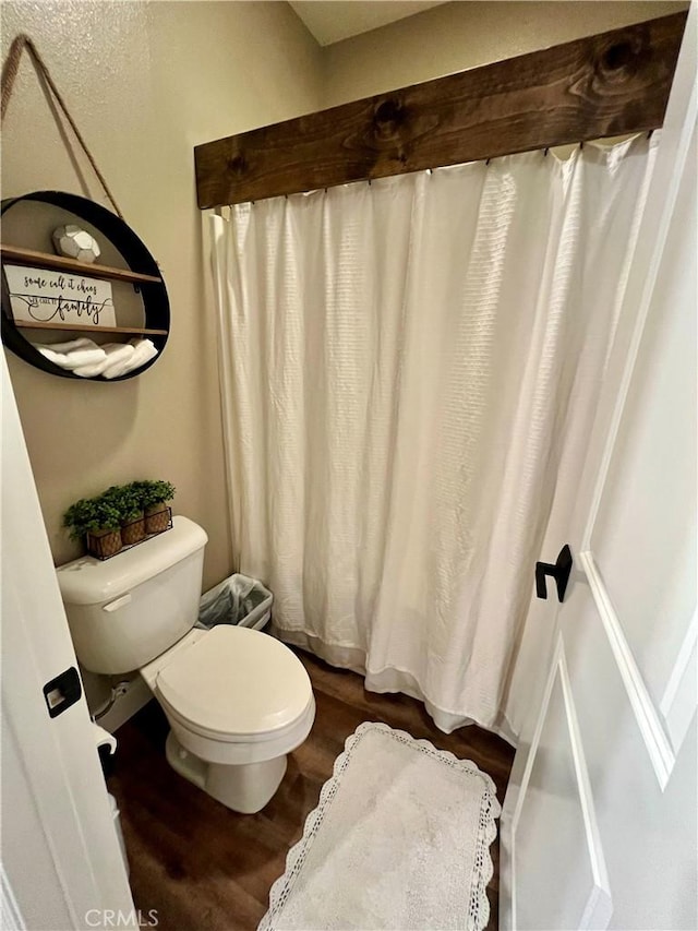 full bathroom featuring wood finished floors and toilet