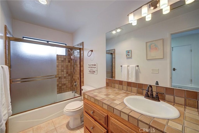 bathroom with shower / bath combination with glass door, vanity, toilet, and tile patterned floors