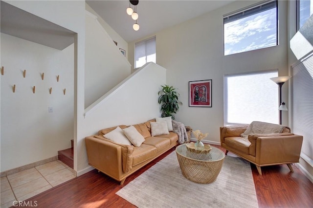 living room featuring stairway, a high ceiling, and wood finished floors