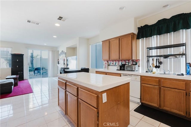 kitchen with dishwasher, tile counters, light tile patterned floors, and visible vents