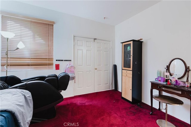 interior space with dark colored carpet, a closet, and baseboards