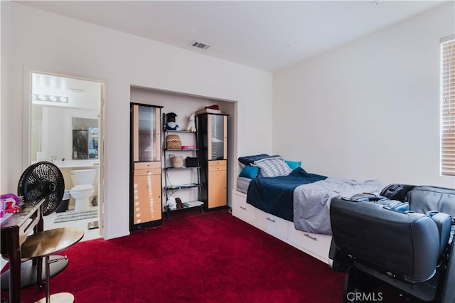 bedroom featuring carpet floors, ensuite bath, and visible vents