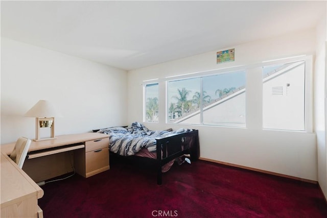 bedroom featuring dark carpet and baseboards