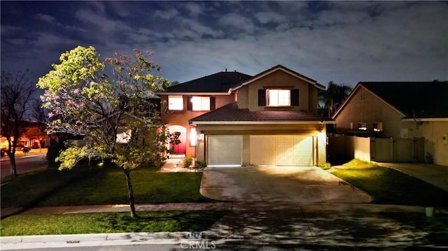 view of front of home featuring an attached garage, fence, concrete driveway, stucco siding, and a front yard