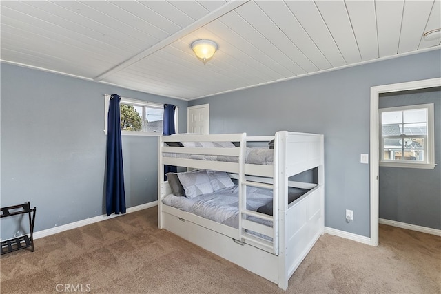 carpeted bedroom with wooden ceiling and baseboards