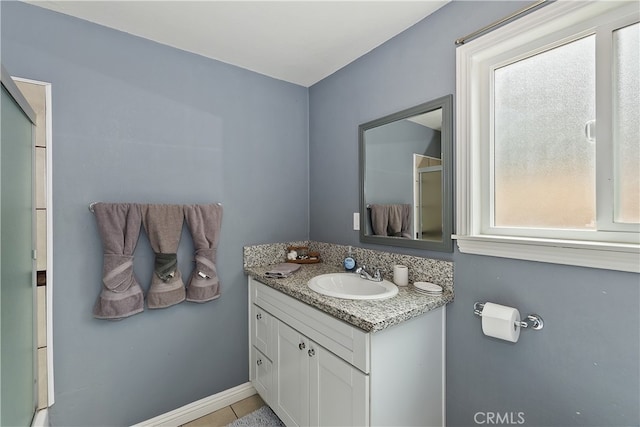 full bath featuring an enclosed shower, vanity, and baseboards