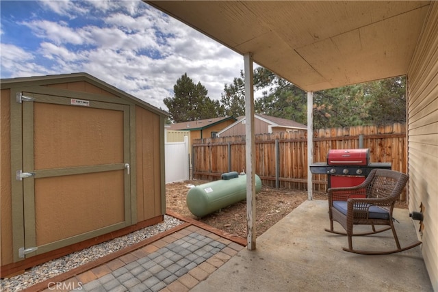 view of patio / terrace with a fenced backyard, a storage unit, grilling area, and an outdoor structure