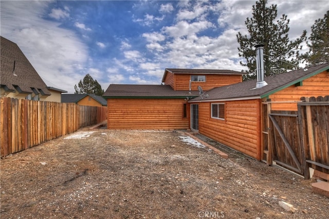 rear view of property with fence and log veneer siding