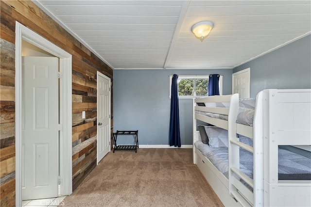 bedroom with carpet floors and wood walls