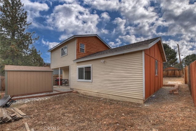 rear view of house featuring a patio area, a fenced backyard, an outdoor structure, and a shed