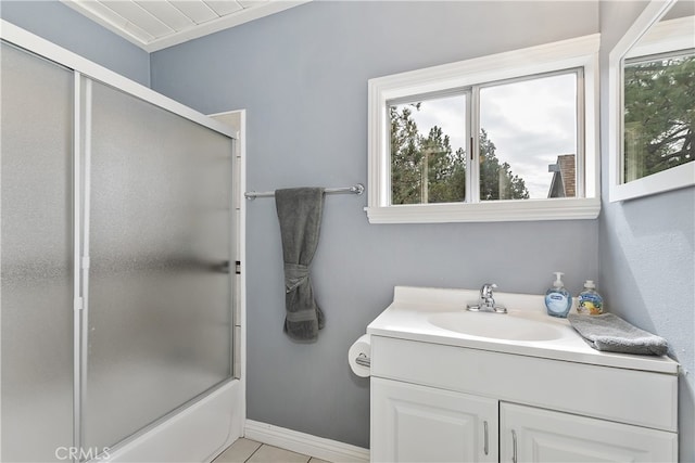 bathroom with baseboards, shower / bath combination with glass door, vanity, and tile patterned floors