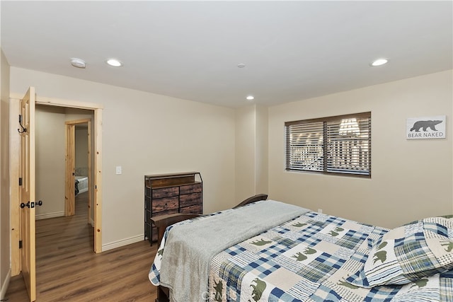 bedroom featuring baseboards, wood finished floors, and recessed lighting