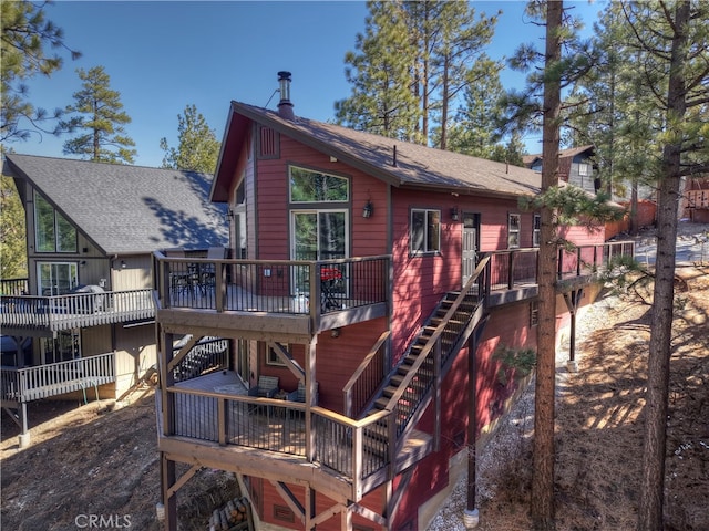 rear view of property with stairs and a wooden deck