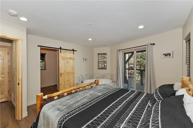 bedroom featuring a barn door, recessed lighting, wood finished floors, baseboards, and access to outside