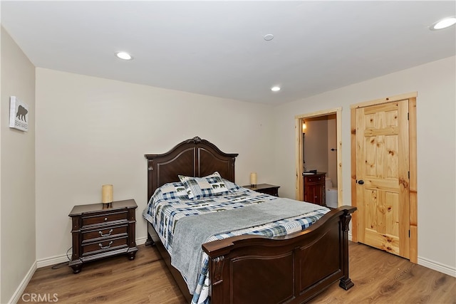 bedroom featuring baseboards, wood finished floors, and recessed lighting