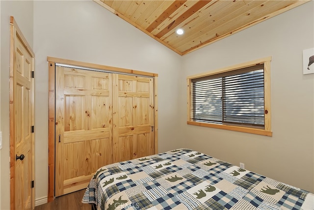 bedroom with lofted ceiling, wooden ceiling, a closet, and dark wood-type flooring