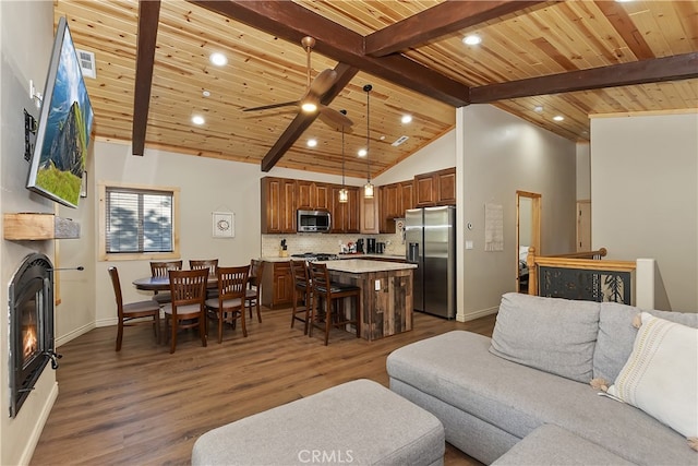 living room featuring wood ceiling, dark wood finished floors, a ceiling fan, beam ceiling, and a glass covered fireplace