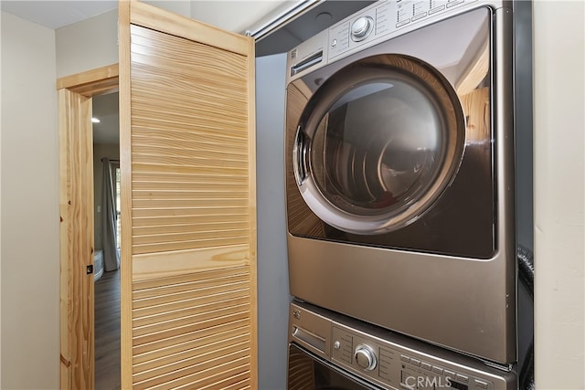 laundry area with stacked washer and dryer, laundry area, and wood finished floors