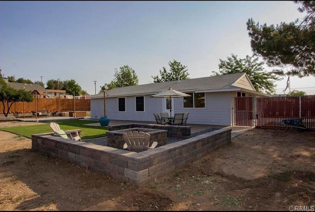 rear view of house featuring a gate, a fire pit, a patio area, and fence