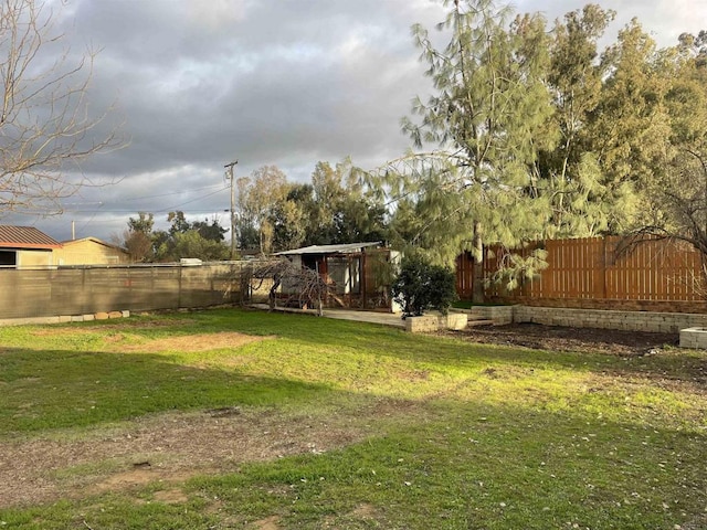 view of yard with an outdoor structure and a fenced backyard