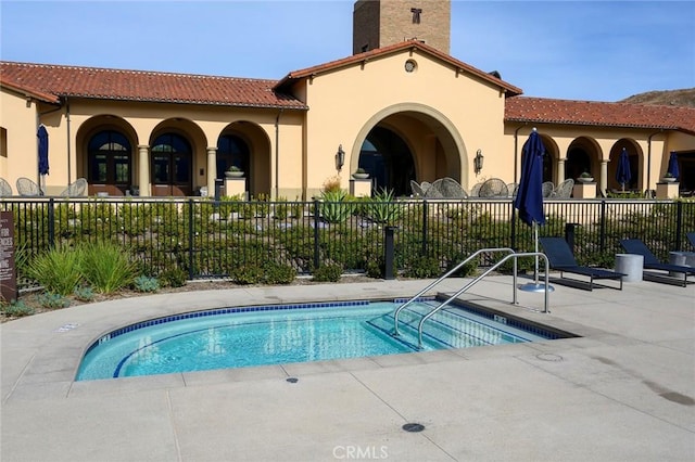 rear view of house featuring a patio, a tiled roof, fence, a pool, and stucco siding