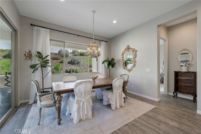 dining area with a notable chandelier, recessed lighting, wood finished floors, and baseboards