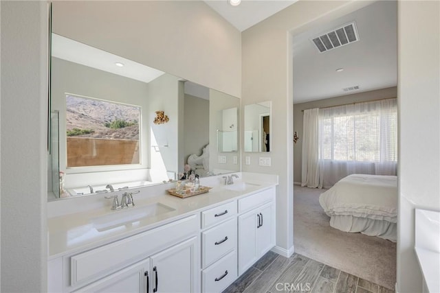 ensuite bathroom featuring visible vents, a sink, and ensuite bathroom