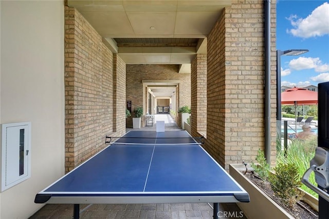 recreation room featuring brick wall