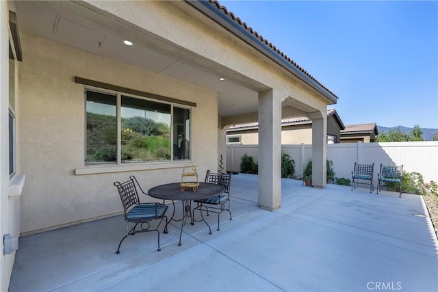 view of patio with outdoor dining area and fence