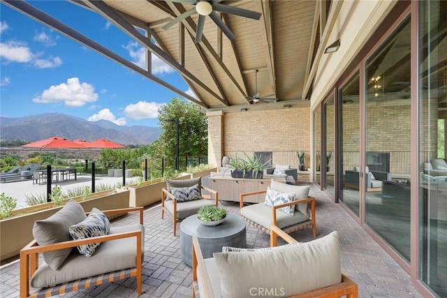 view of patio featuring outdoor lounge area, a mountain view, and ceiling fan