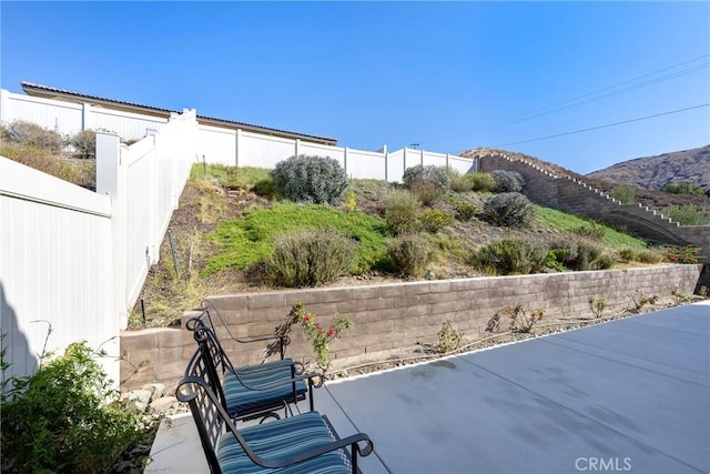 view of patio featuring fence and a mountain view