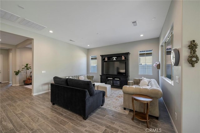 living room featuring recessed lighting, wood finished floors, visible vents, and baseboards