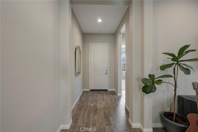 hall featuring baseboards and wood finished floors