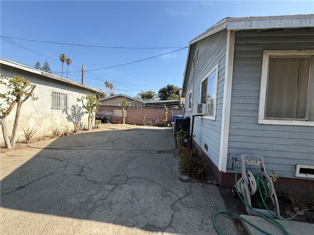 view of side of property with fence, cooling unit, and a patio