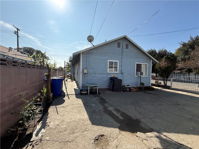 rear view of house with cooling unit, a patio area, and a fenced backyard