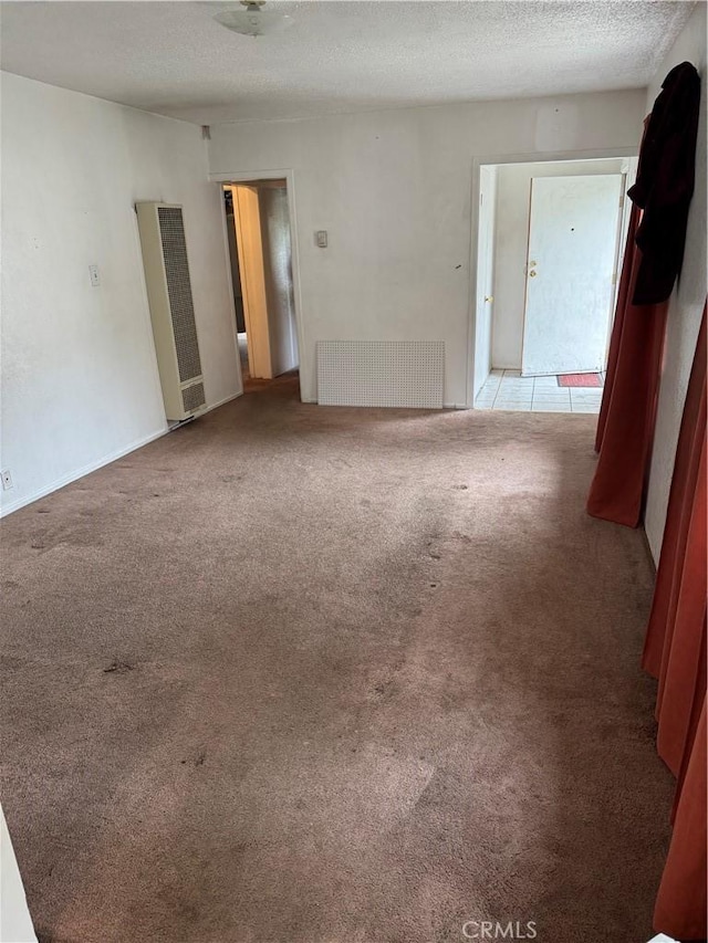 carpeted empty room with a textured ceiling