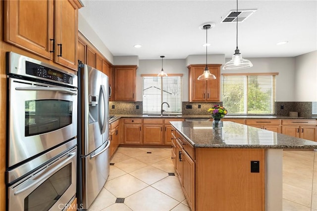 kitchen featuring a wealth of natural light, visible vents, stainless steel appliances, and a sink