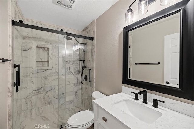 full bath featuring a textured wall, toilet, vanity, visible vents, and a marble finish shower