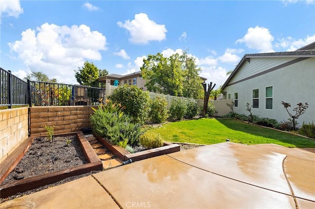 view of yard with a patio area, a fenced backyard, and a garden