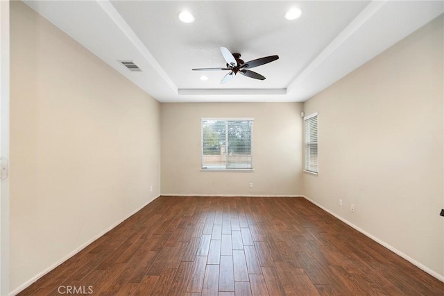 spare room featuring ceiling fan, recessed lighting, dark wood-style flooring, visible vents, and a tray ceiling