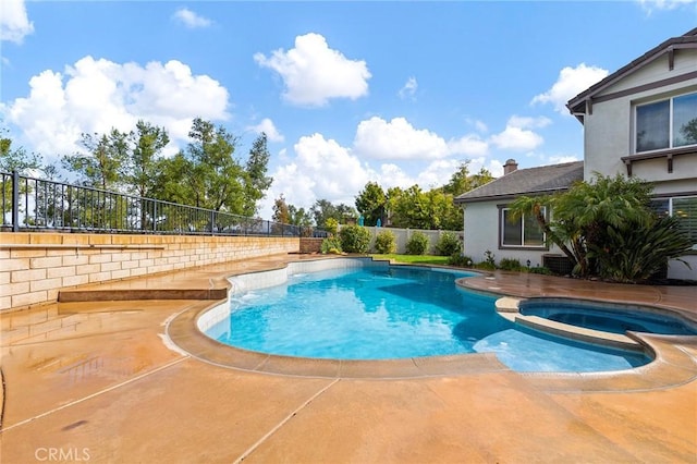 view of pool with a patio area, fence, and a pool with connected hot tub