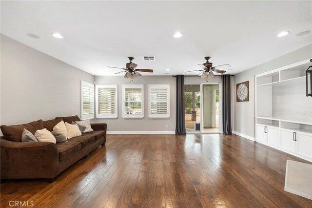 living area with baseboards, visible vents, dark wood finished floors, and recessed lighting