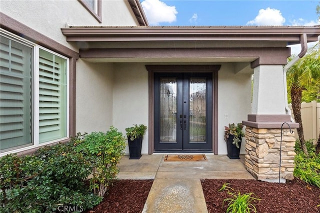 property entrance with french doors and stucco siding