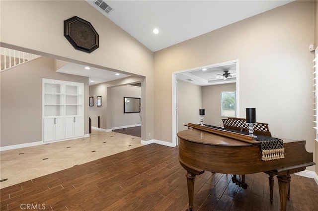 living area featuring baseboards, visible vents, ceiling fan, and wood finished floors